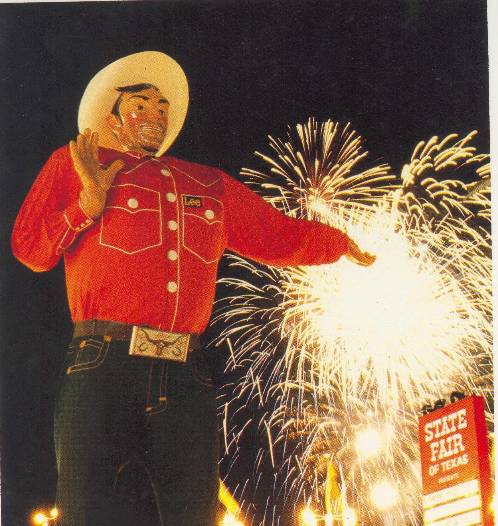 Big Tex at the State Fair of Texas with fireworks lighting the night sky.