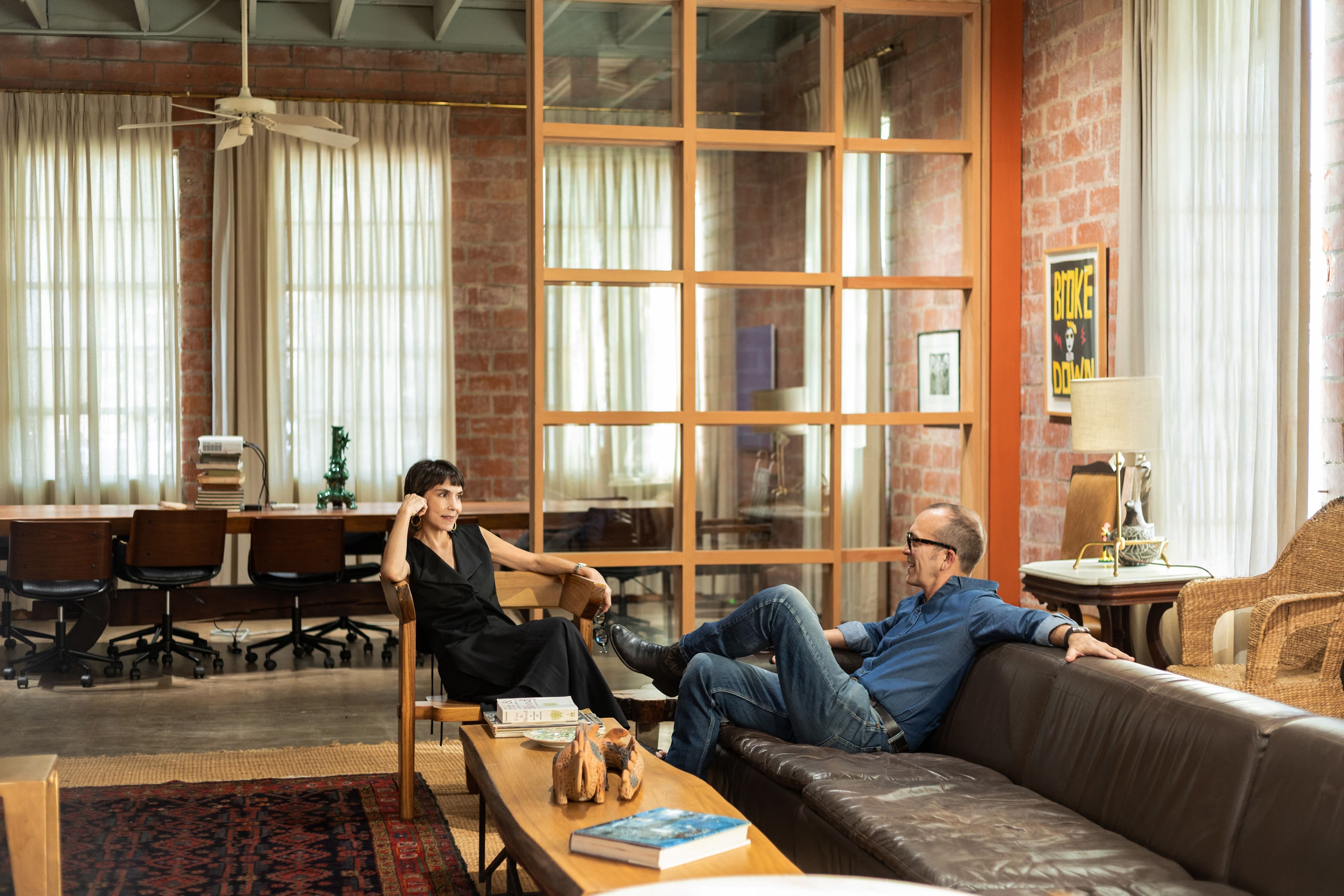 A man and a woman lounge in a living room